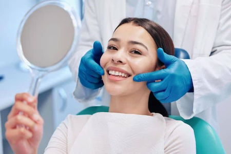 woman looking into hand mirror with a smile